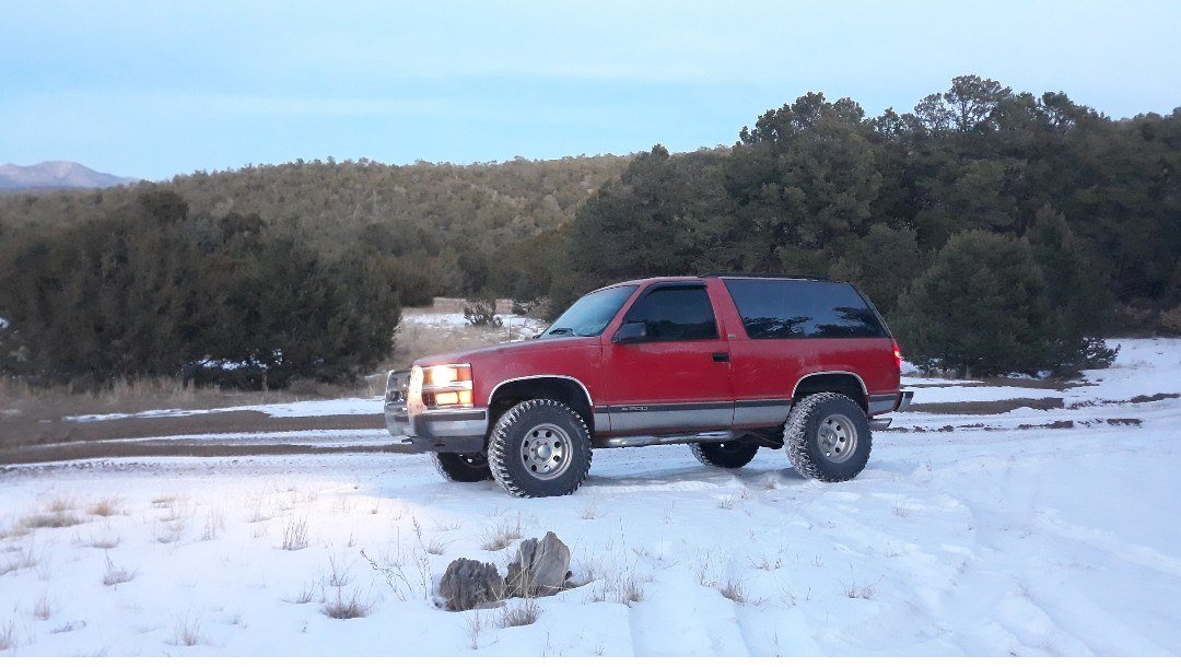 Red lifted 4x4 SUV parked in a snowy landscape